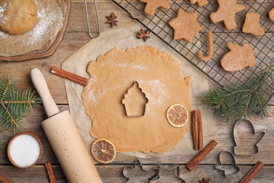 Photo of Making homemade Christmas cookies. Flat lay composition with dough and cutters on wooden background