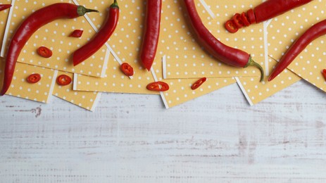 Pepper plasters and chili on white wooden table, flat lay. Space for text