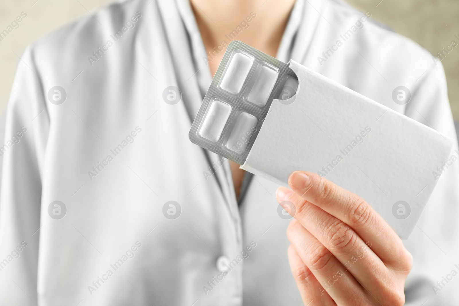 Photo of Woman holding blister with chewing gums, closeup