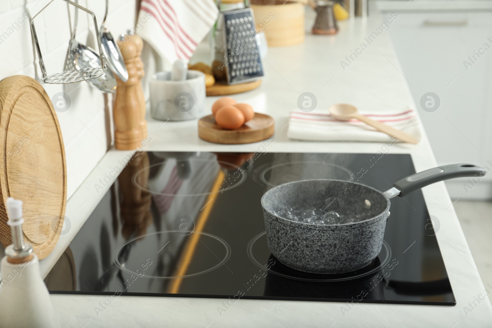 Photo of Saucepan with boiling water on electric stove in kitchen. Cooking utensil