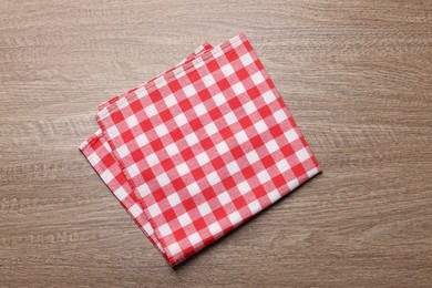 Photo of Checkered tablecloth on wooden table, top view