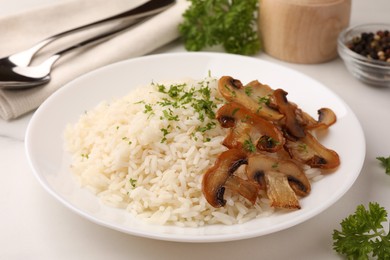 Photo of Delicious rice with parsley and mushrooms on white table