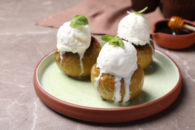 Delicious baked apples with ice cream and mint served on grey table, space for text