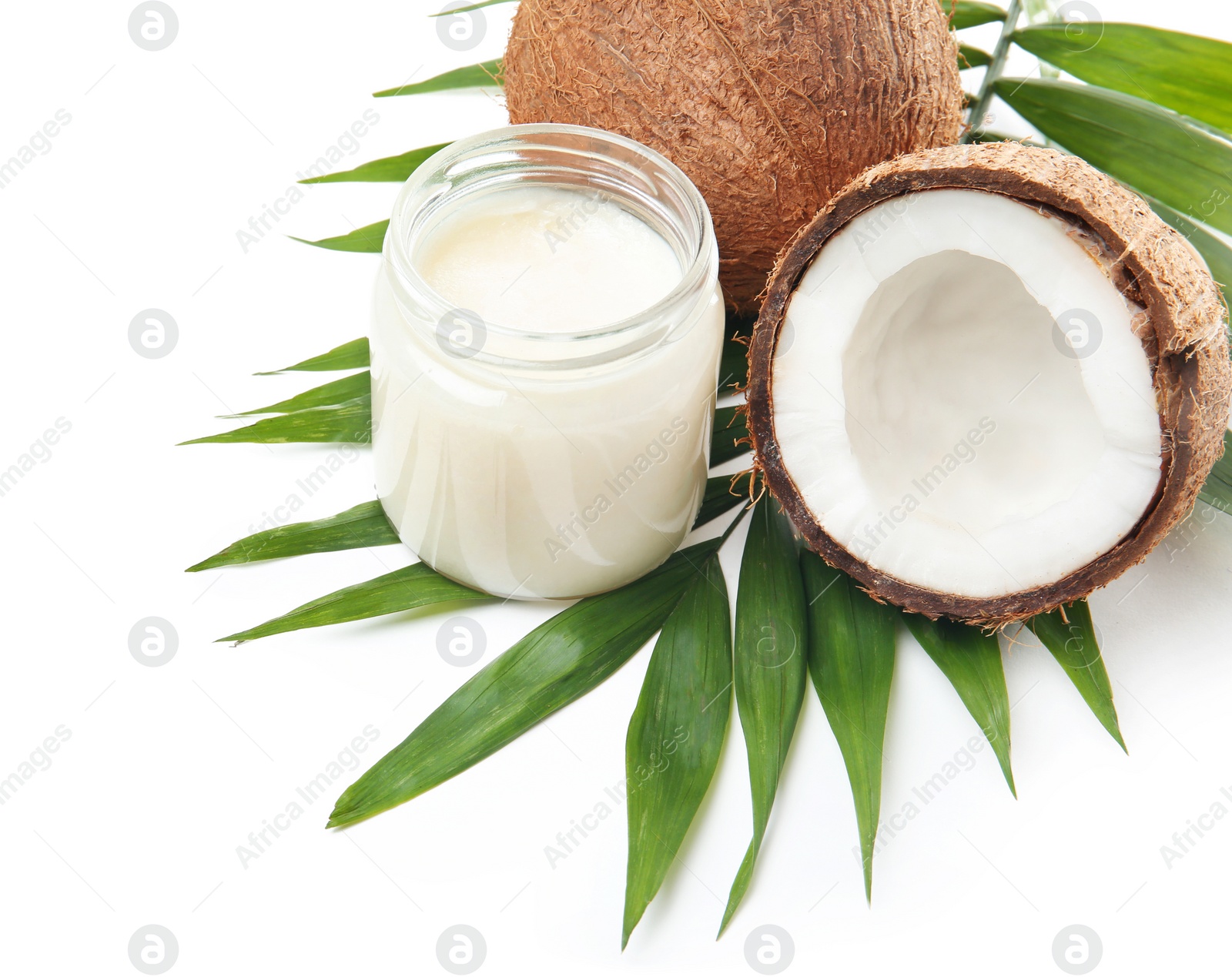 Photo of Jar with coconut oil and nuts on white background