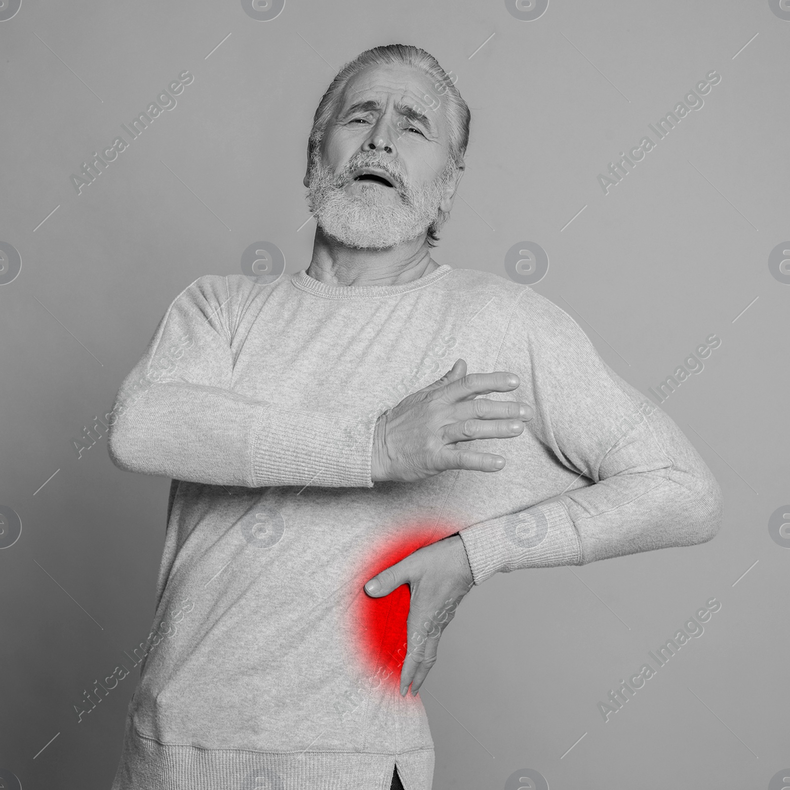 Image of Senior man suffering from rheumatism on light background. Black and white effect with red accent in painful area