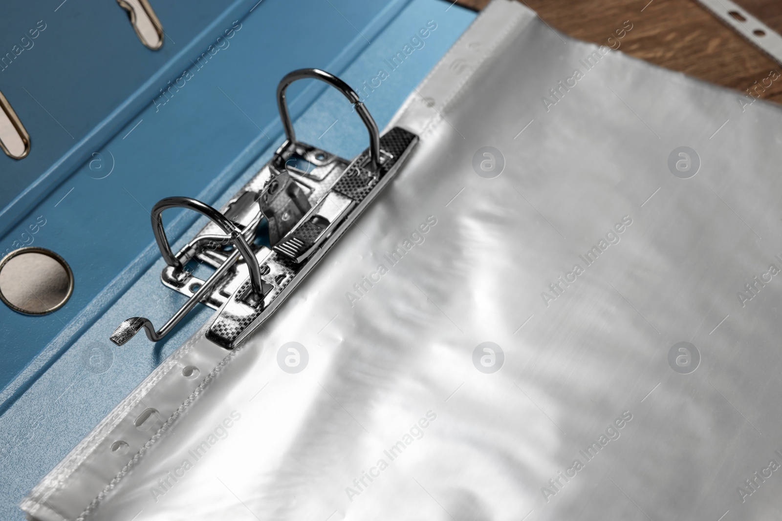 Photo of File folder with punched pockets on wooden table, closeup