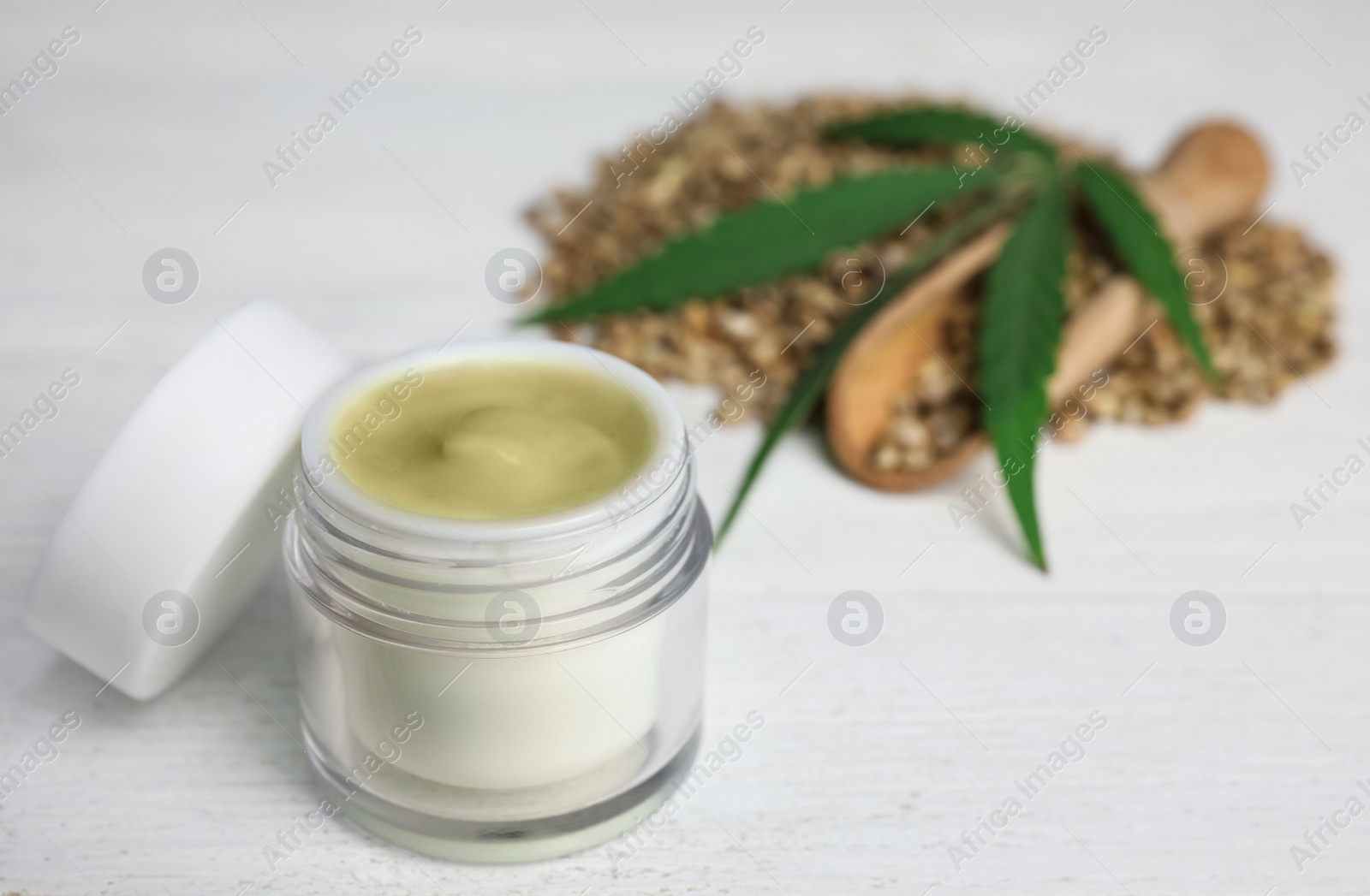 Photo of Jar of hemp cream on white wooden table. Organic cosmetics