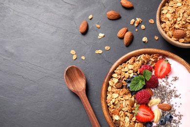 Photo of Healthy homemade granola with yogurt on dark grey table, flat lay. Space for text