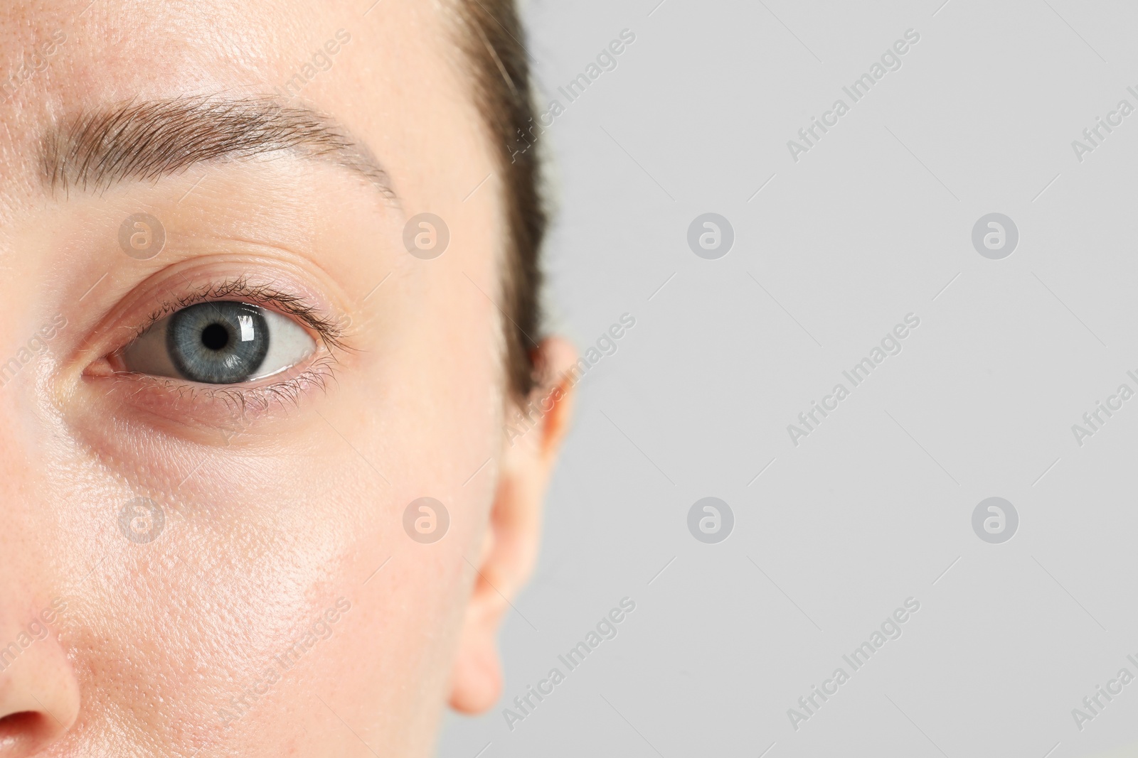 Photo of Closeup photo of woman with beautiful eyes on light background. Space for text