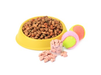 Dry pet food in bowl, vitamins and toys isolated on white