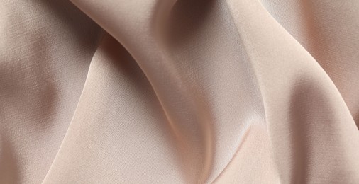 Photo of Texture of beige crumpled silk fabric as background, top view