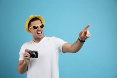 Photo of Male tourist with camera on turquoise background