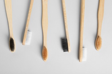 Photo of Many different bamboo toothbrushes on white background, flat lay