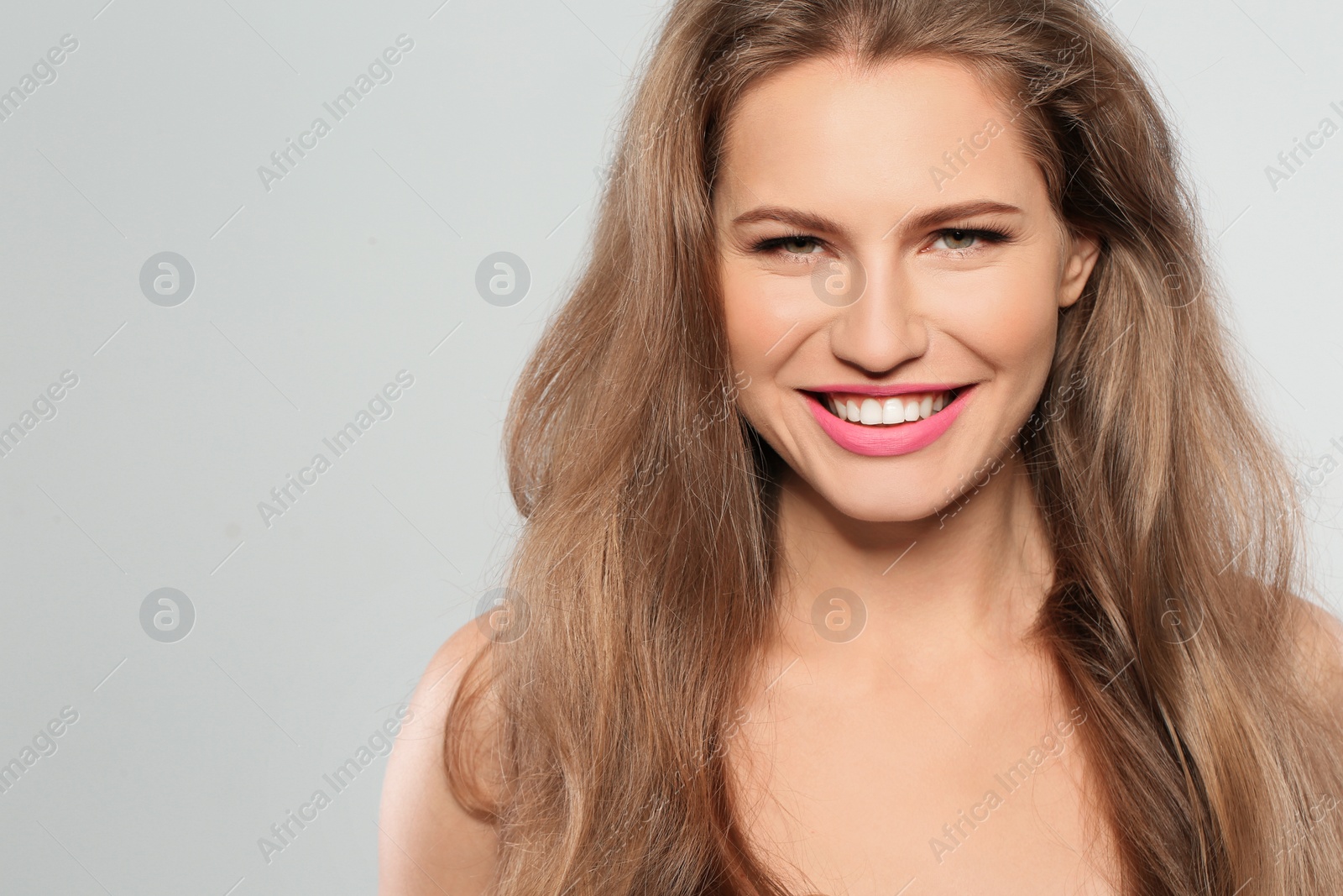Photo of Young woman wearing beautiful lipstick on gray background. Space for text
