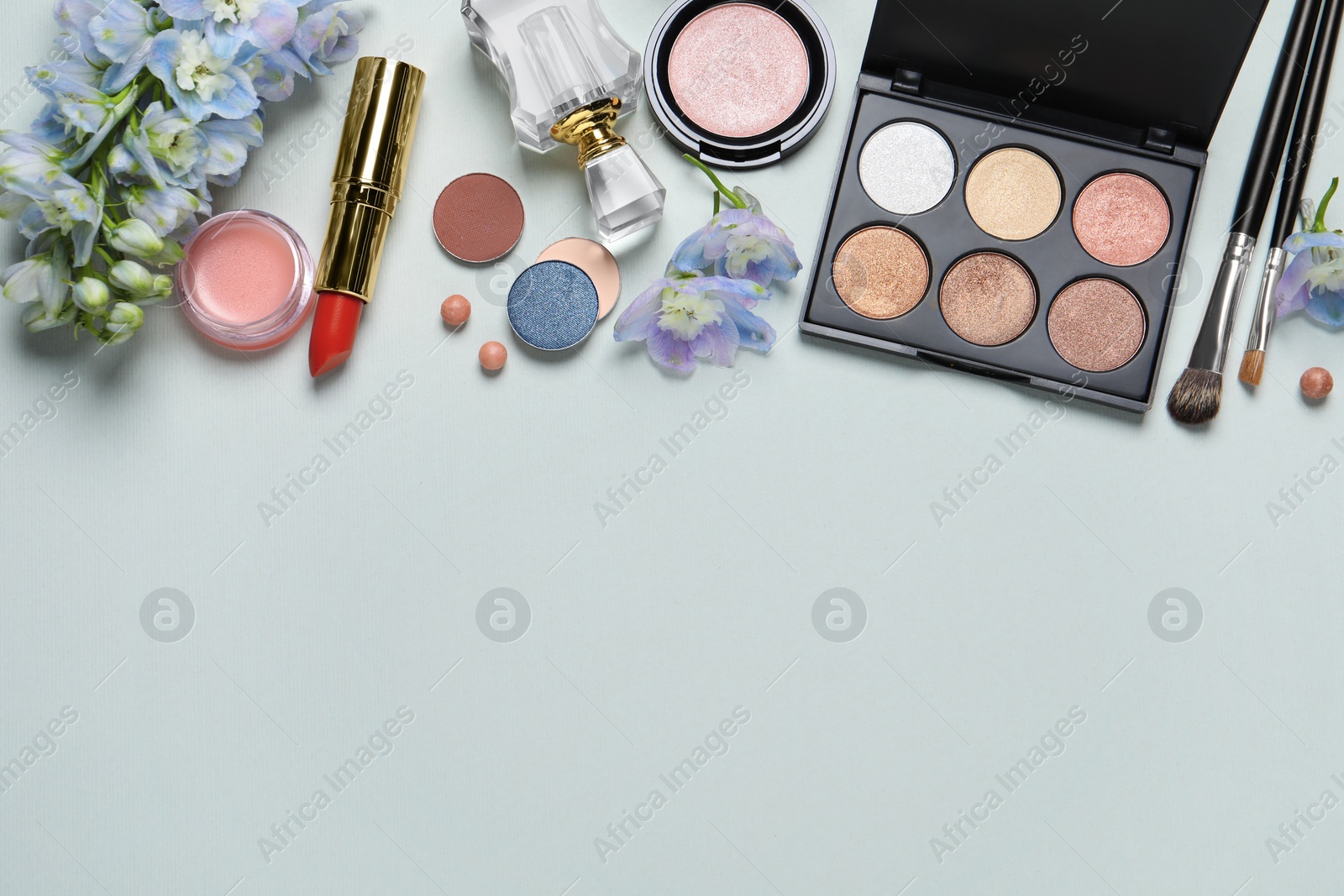 Photo of Flat lay composition with eyeshadow palette and beautiful flowers on white background, space for text