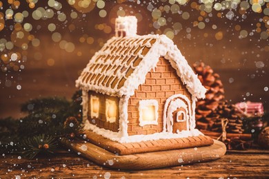 Image of Beautiful gingerbread house decorated with icing on wooden table