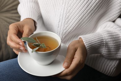 Photo of Woman drinking tasty herbal tea, closeup view