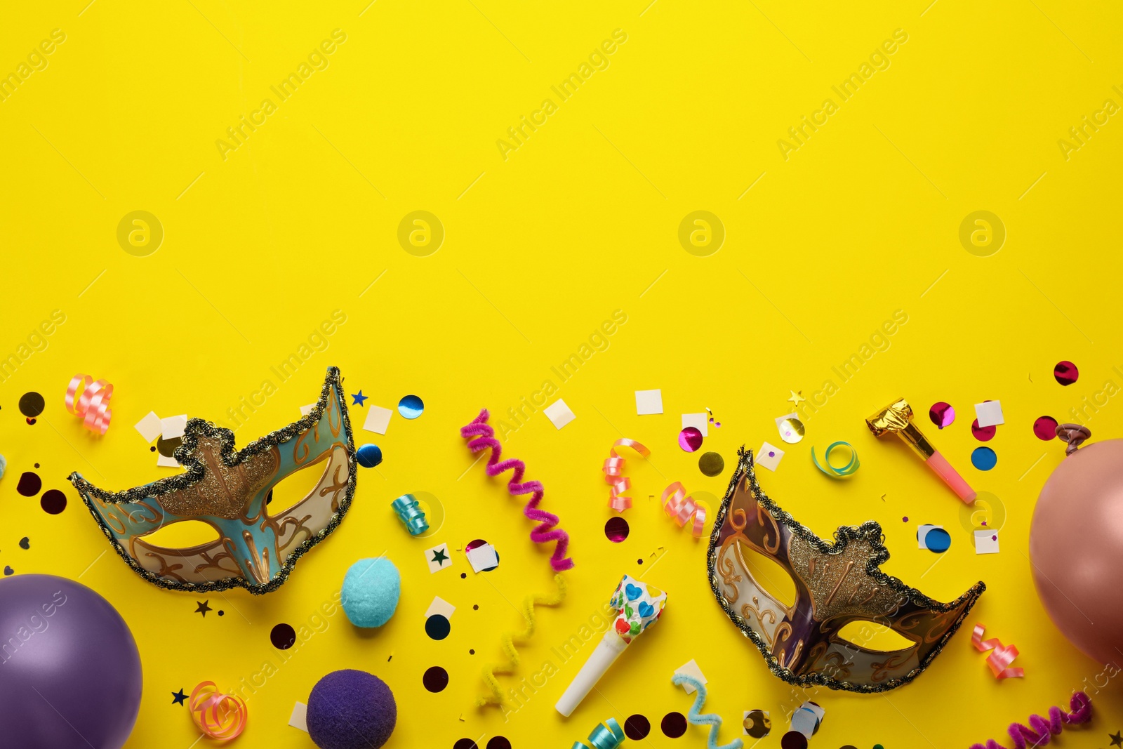 Photo of Flat lay composition with carnival items on yellow background. Space for text