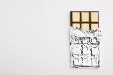 Tasty chocolate bar on white background, top view