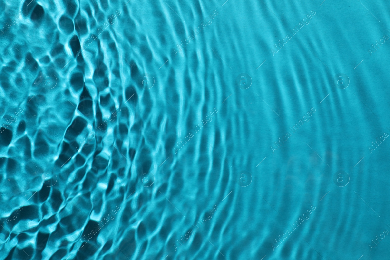 Photo of Rippled surface of clear water on light blue background, top view