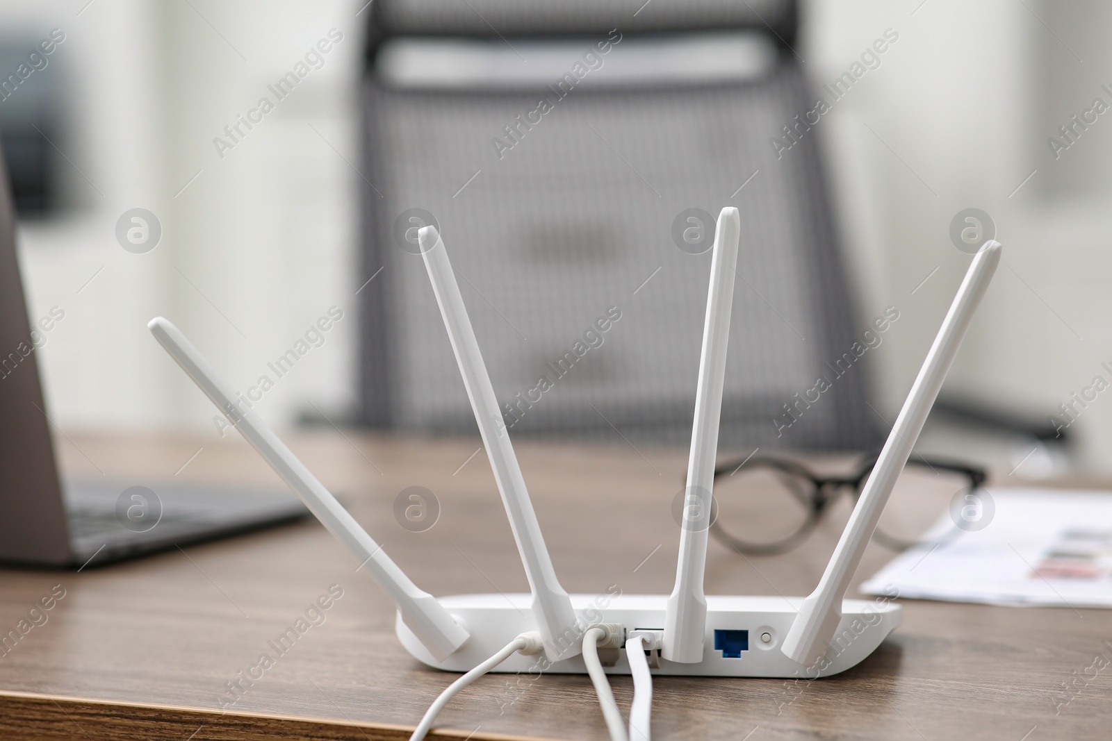 Photo of Modern Wi-Fi router on wooden table indoors