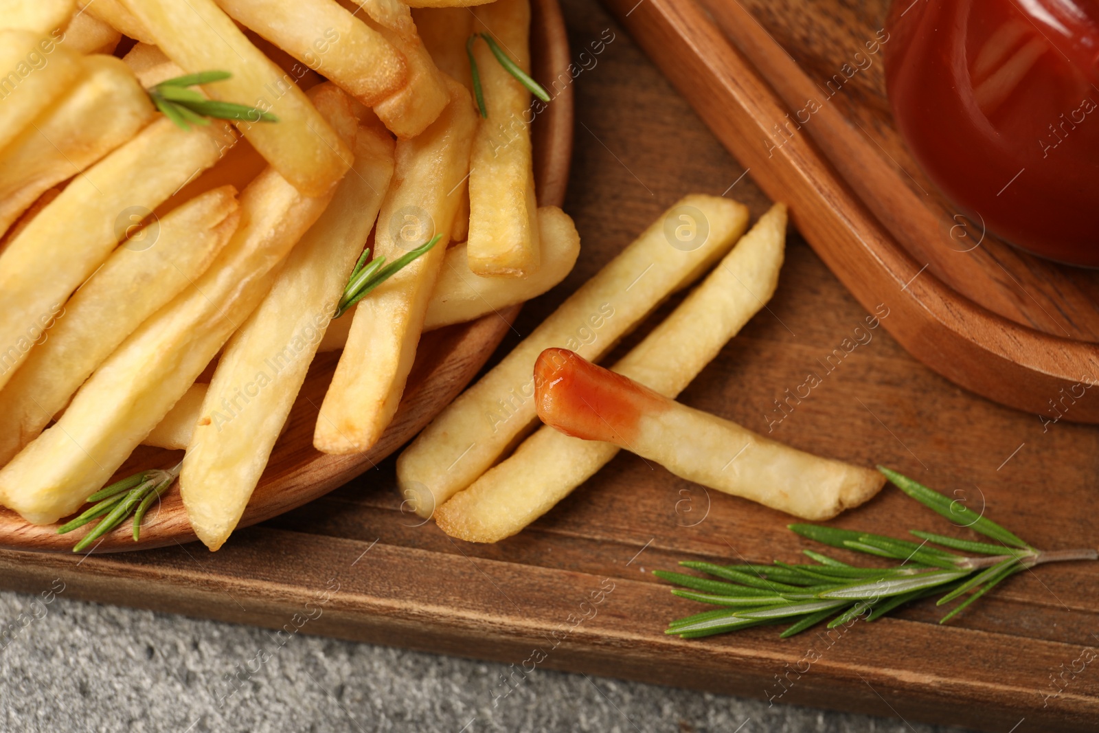 Photo of Delicious French fries served with sauce on grey textured table, closeup