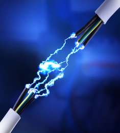 Sparking cables on dark blue background, closeup. Electrician's supply