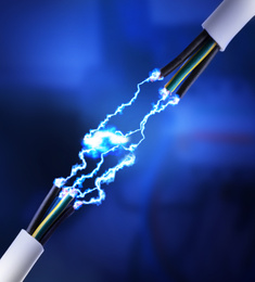 Image of Sparking cables on dark blue background, closeup. Electrician's supply