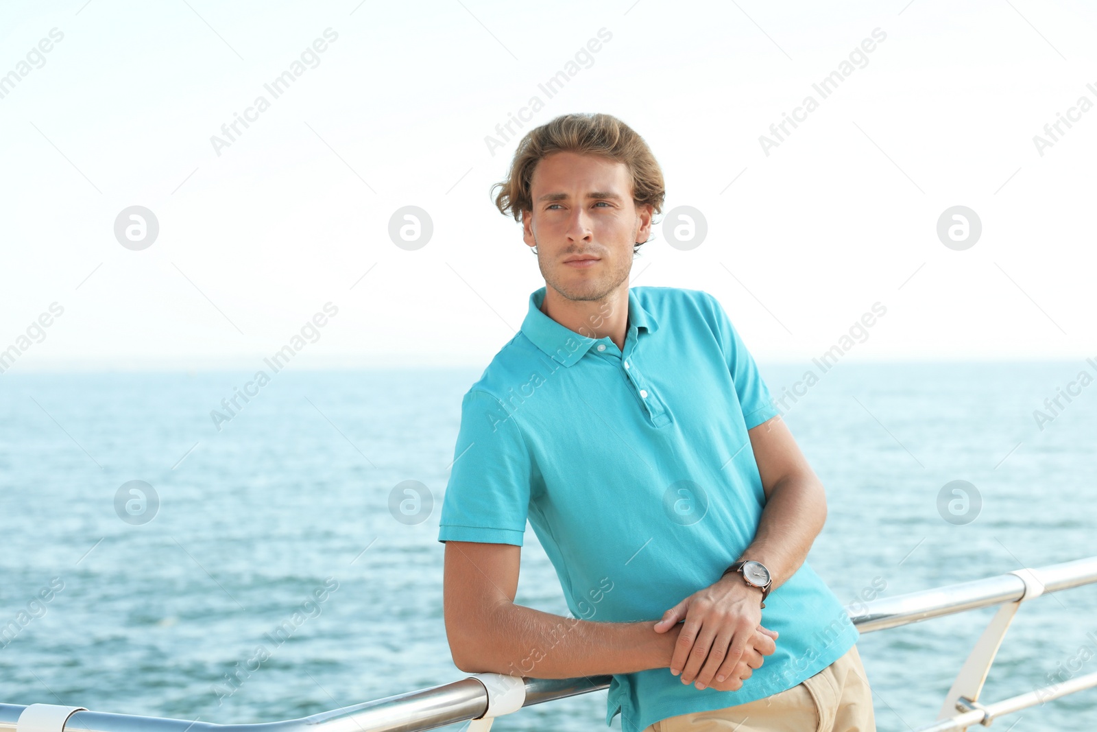Photo of Portrait of handsome young man on sea pier