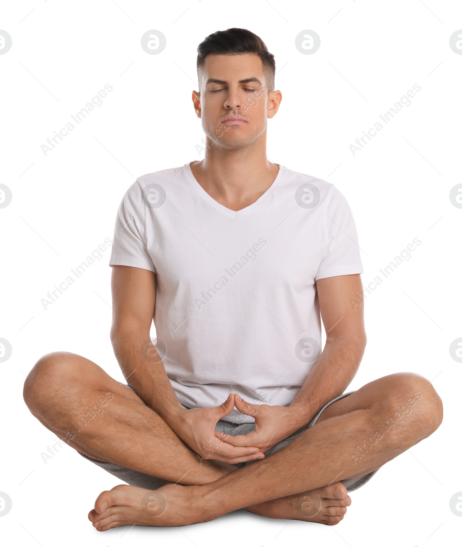 Photo of Handsome man meditating on white background. Harmony and zen