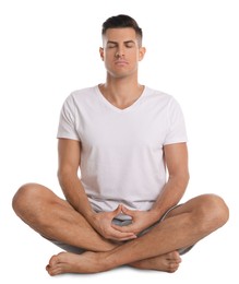 Handsome man meditating on white background. Harmony and zen