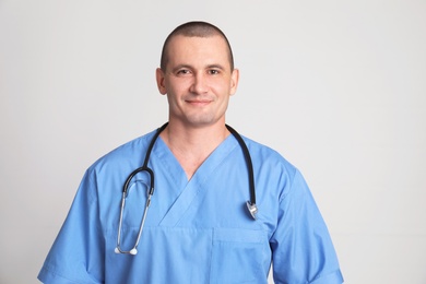 Portrait of medical assistant with stethoscope on color background