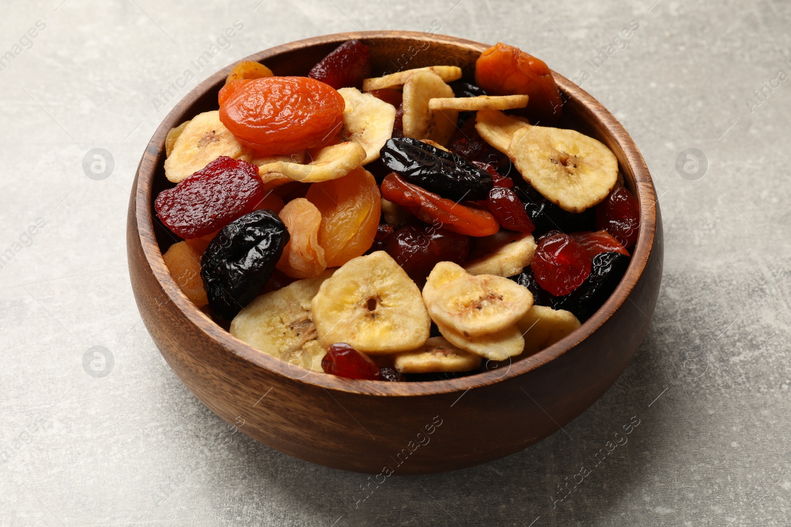 Photo of Mix of delicious dried fruits on grey table, closeup