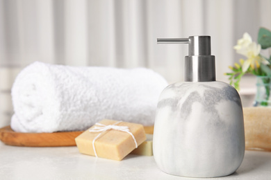 Photo of Soap dispenser and toiletries on white table