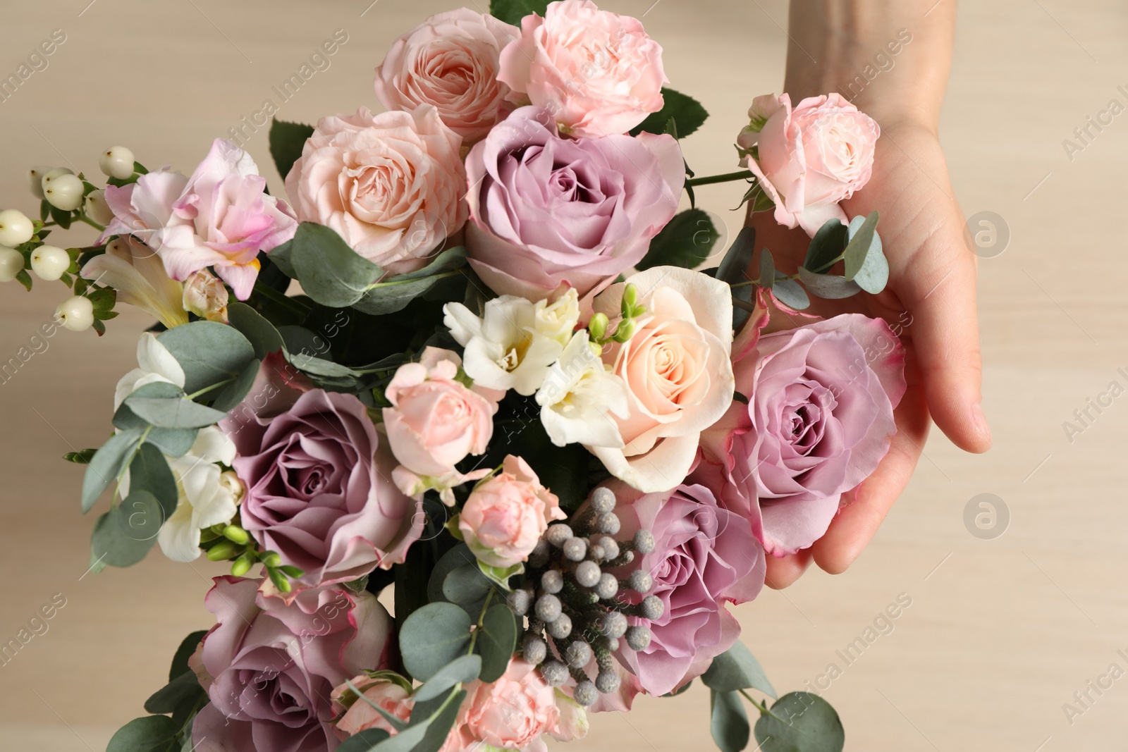 Photo of Florist creating beautiful bouquet at table, top view