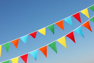Photo of Buntings with colorful triangular flags against blue sky