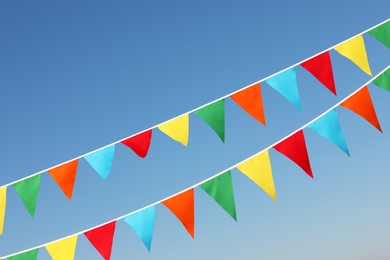 Buntings with colorful triangular flags against blue sky