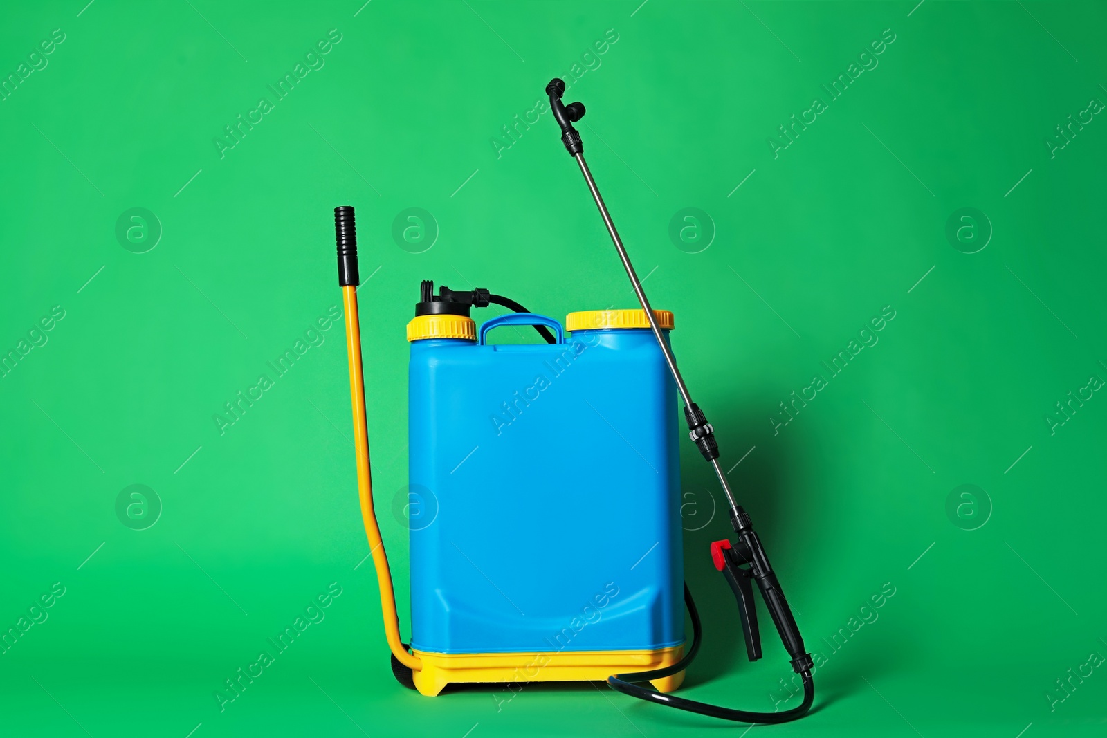 Photo of Manual insecticide sprayer on green background. Pest control