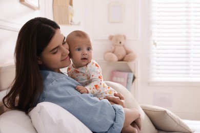 Mother with her cute baby on bed at home