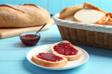 Tasty fresh bread with jam on light blue wooden table