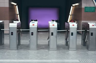 Photo of Many modern turnstiles outdoors. Fare collection system