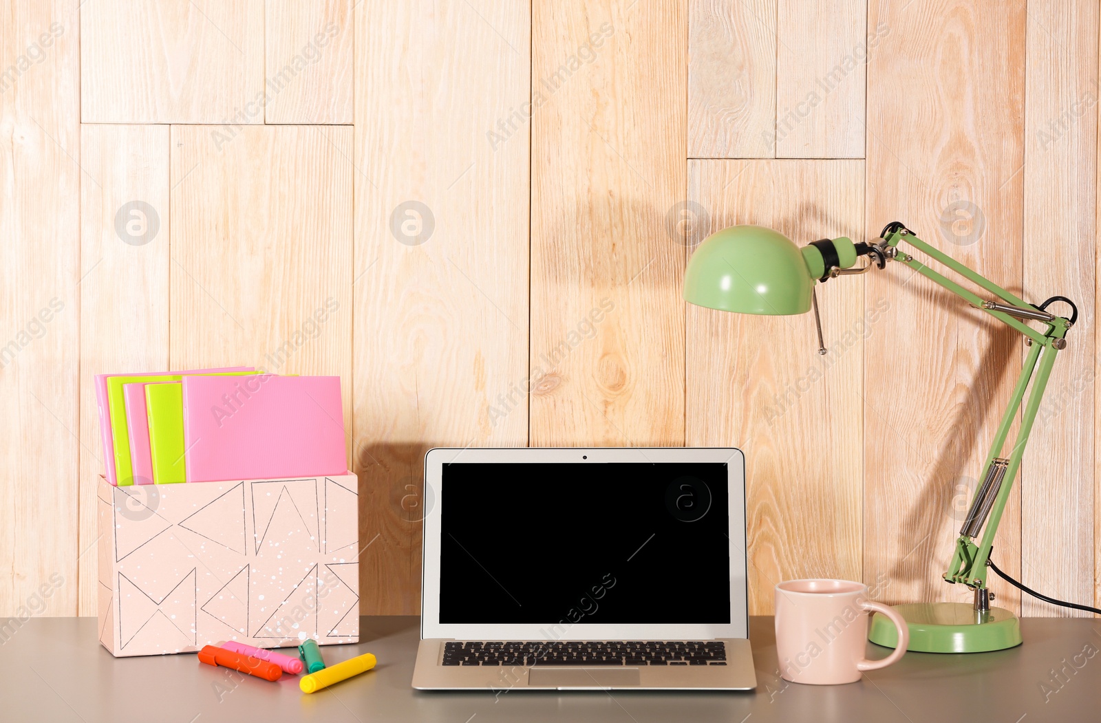 Photo of Laptop with blank screen at table indoors. Mock up for design