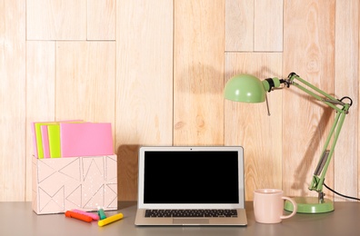 Photo of Laptop with blank screen at table indoors. Mock up for design