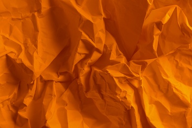 Texture of orange crumpled paper as background, top view