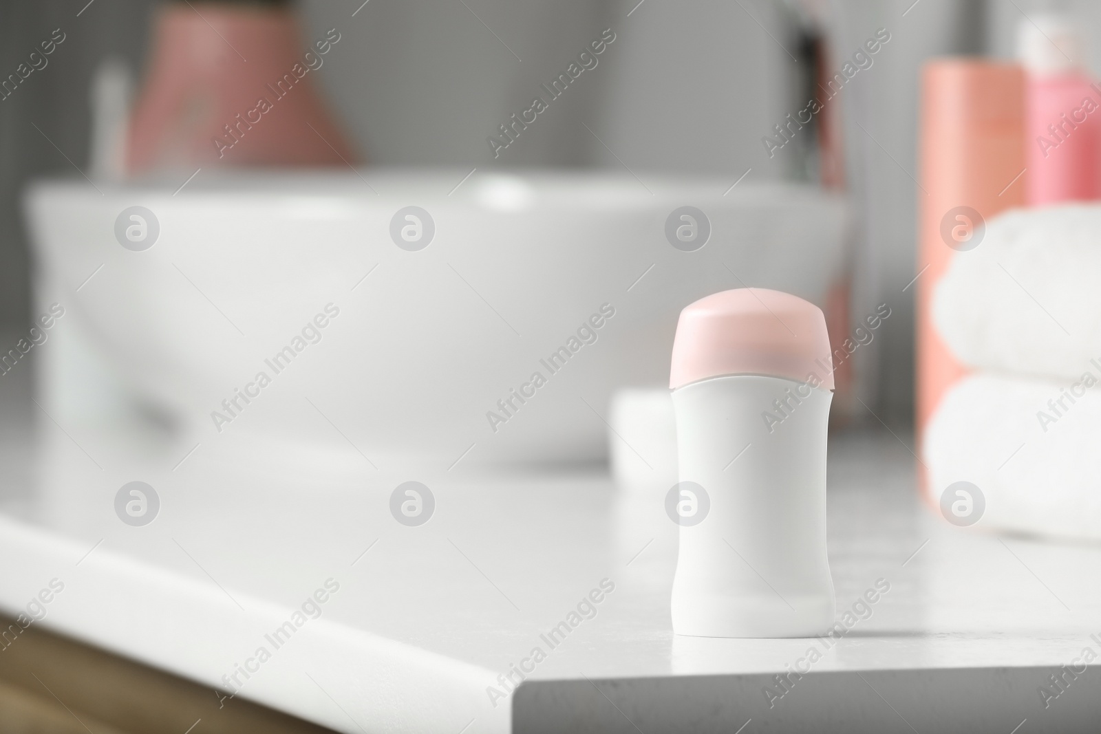Photo of Stick deodorant and different toiletry on countertop in bathroom, space for text