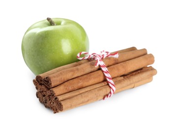 Photo of Cinnamon sticks and green apple on white background