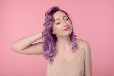 Trendy hairstyle. Young woman with colorful dyed hair on pink background