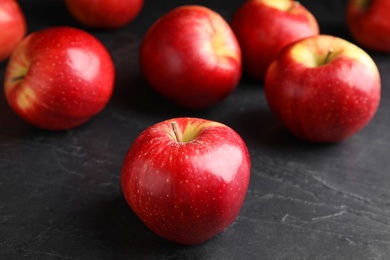 Fresh ripe red apples on black table, closeup
