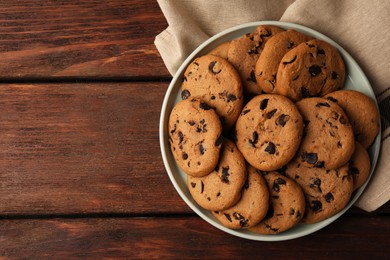 Photo of Delicious chocolate chip cookies on wooden table, top view. Space for text