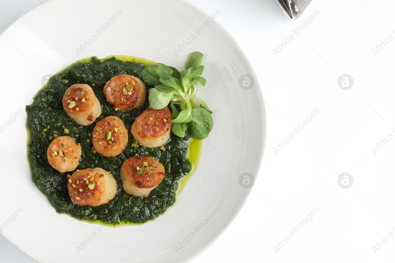 Photo of Delicious fried scallops with tasty sauce and corn salad in bowl isolated on white, top view